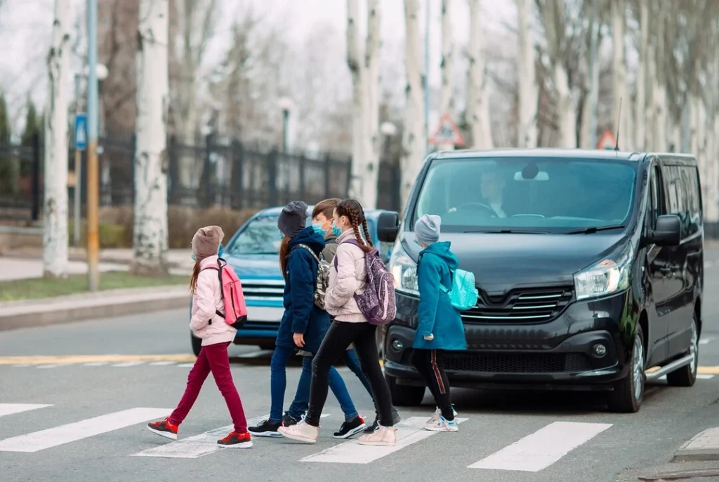 group transportation van is stopped on zebra crossing.